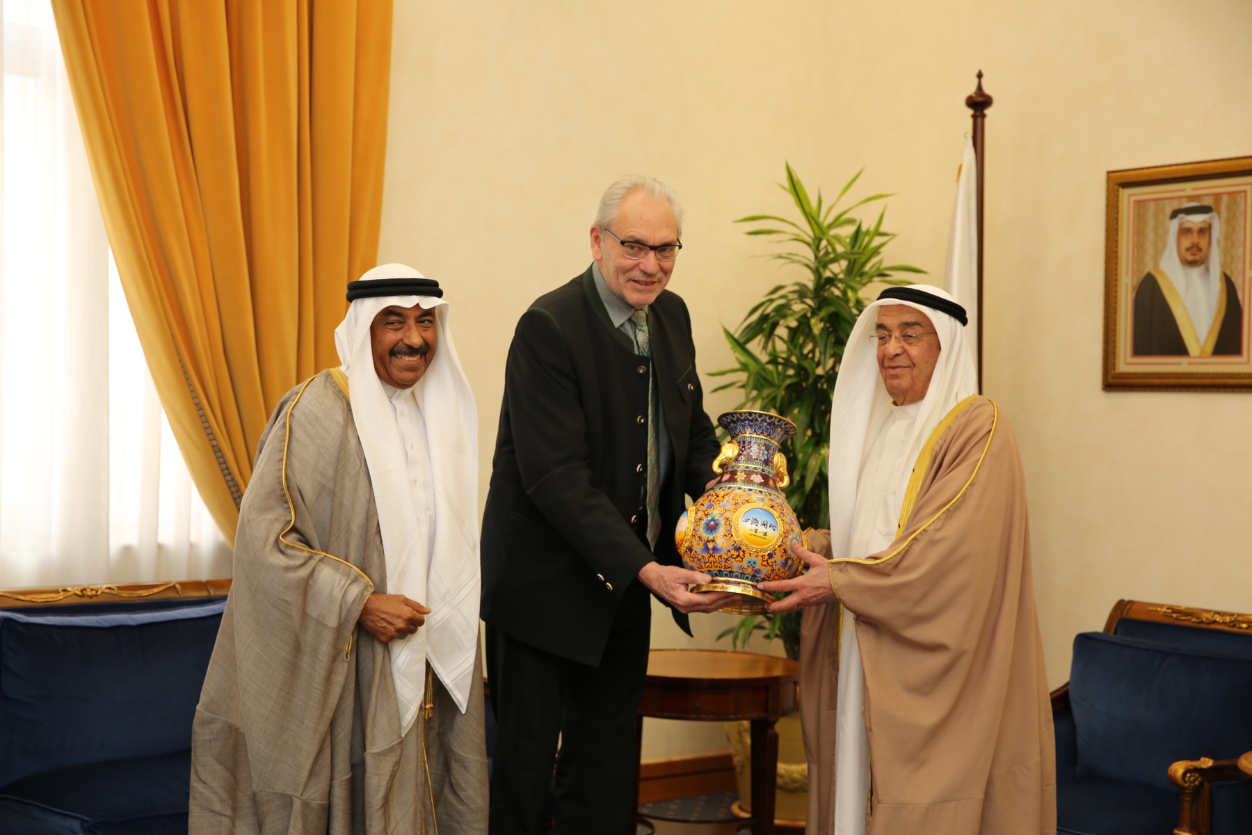 Three participants present a decorated vase during an Executive Board visit in Bahrain